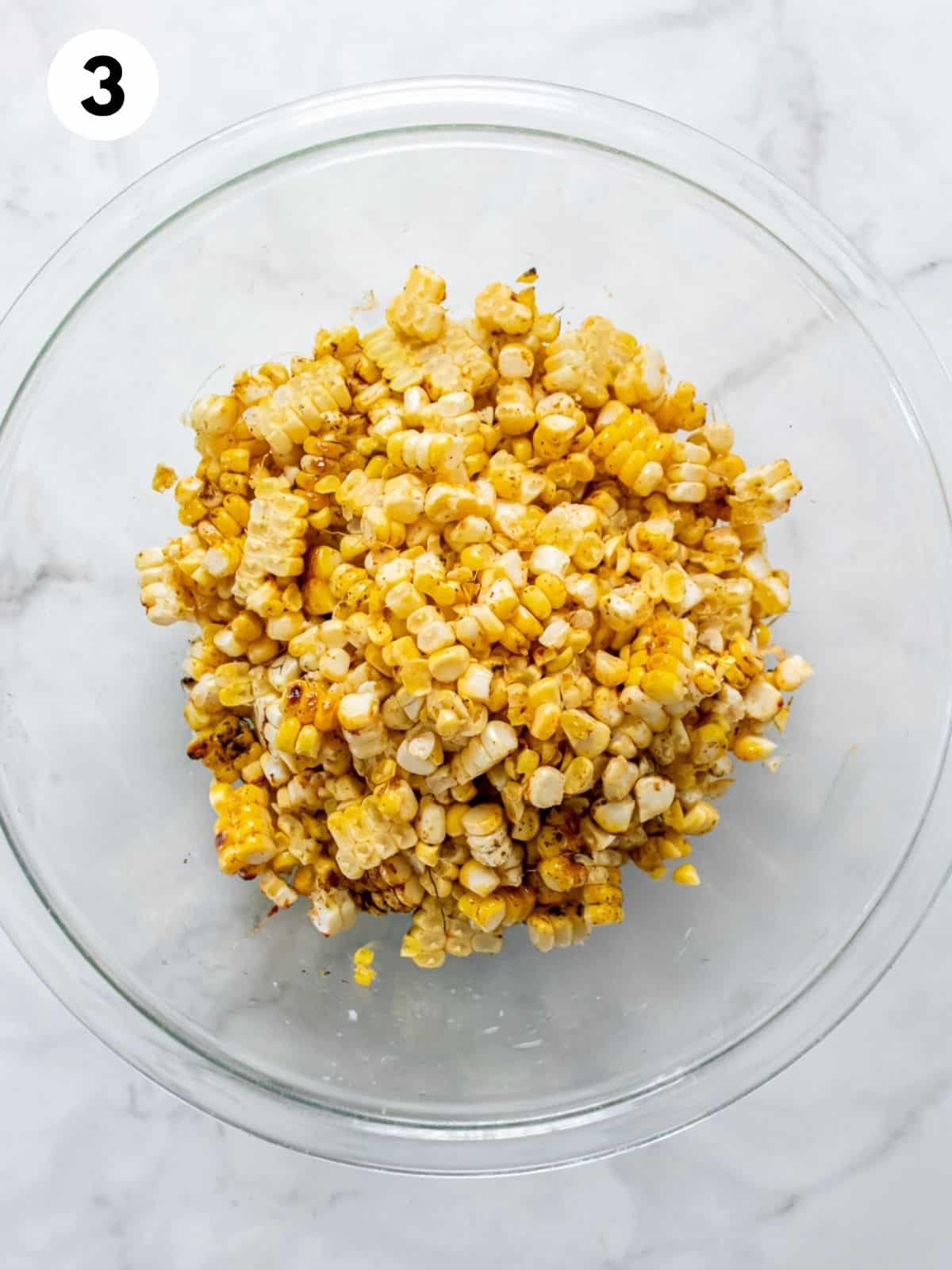 Corn kernels in a clear glass bowl.