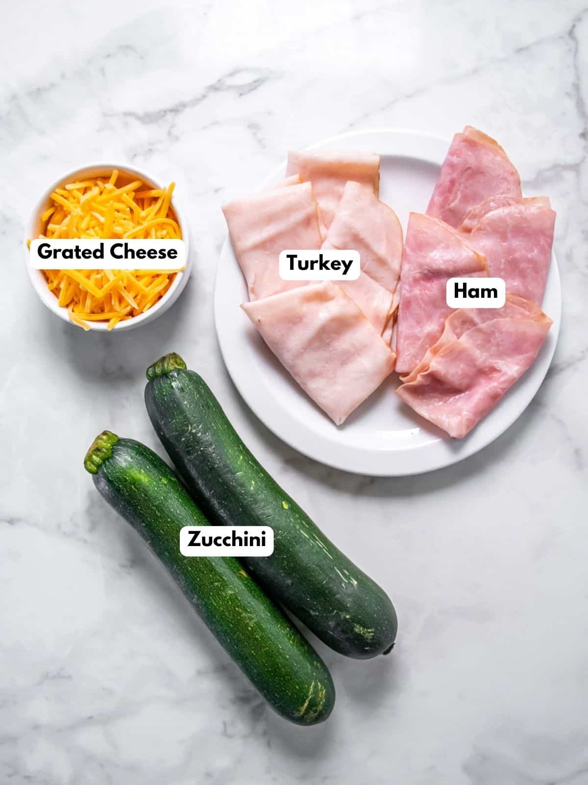 Ingredients to make healthy zucchini boats with labels to identify each one. 