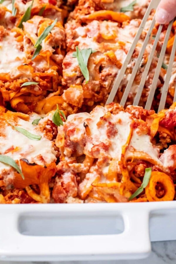 A spatula scooping up a serving of ground turkey casserole from the dish.
