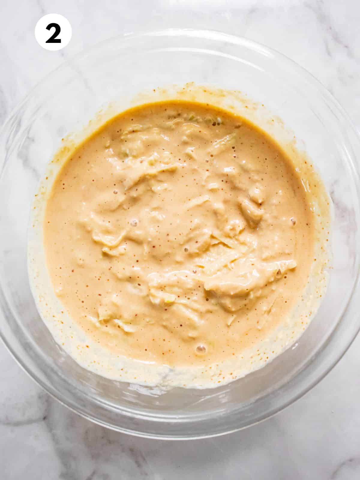 Apple muffin batter mixed in a glass bowl.
