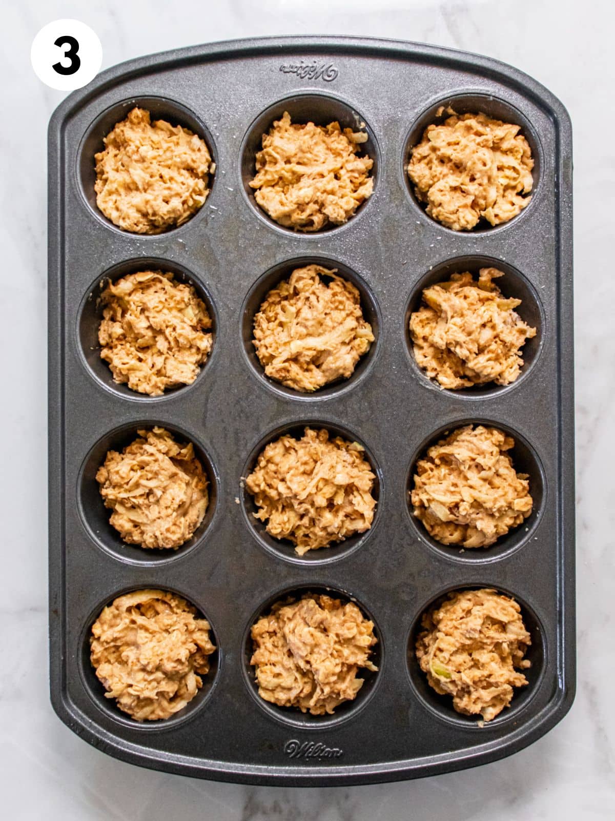Batter scooped into a muffin pan.