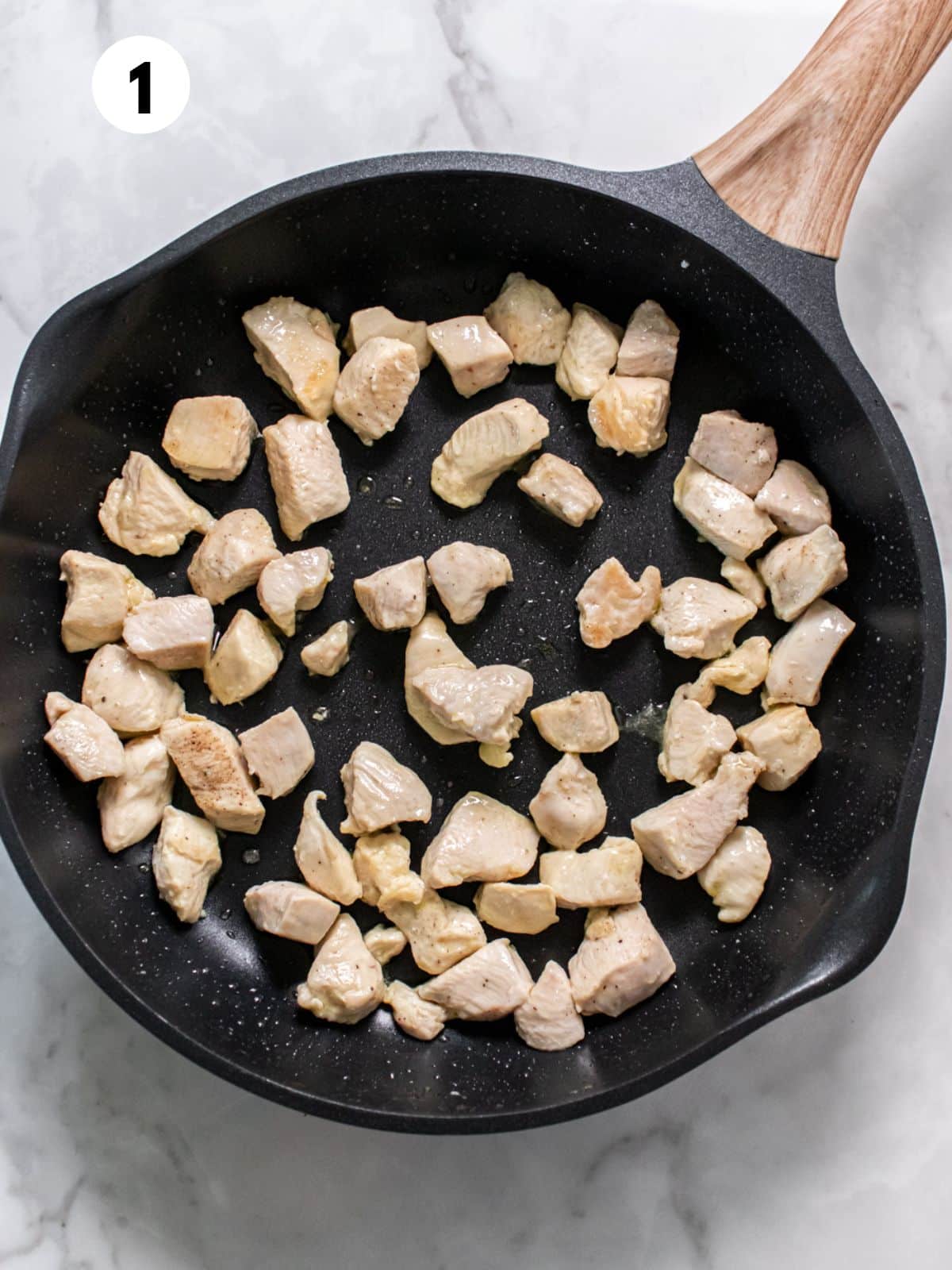 Chicken cooking in a skillet.