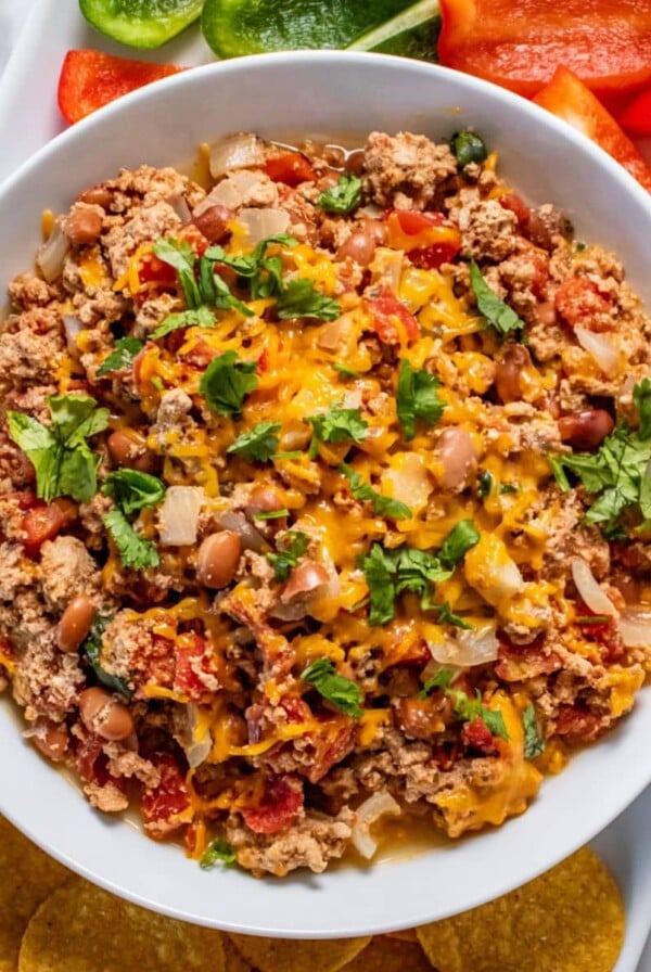 A bowl of crockpot chili cheese dip on the table.