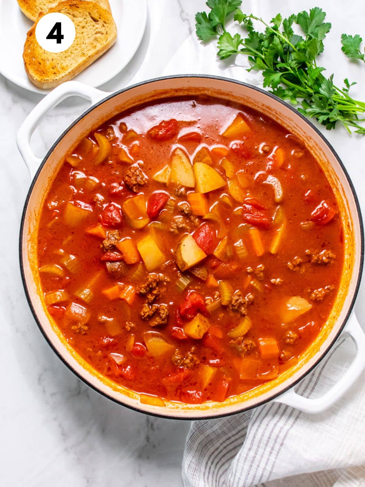 Old fashioned beef vegetable soup cooked in a Dutch oven.