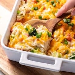 Ham potato broccoli casserole with a spoon lifting up a serving.