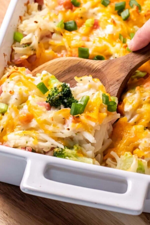 Ham potato broccoli casserole with a spoon lifting up a serving.