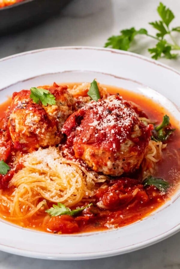 A plate of turkey veggie meatballs over spaghetti squash.