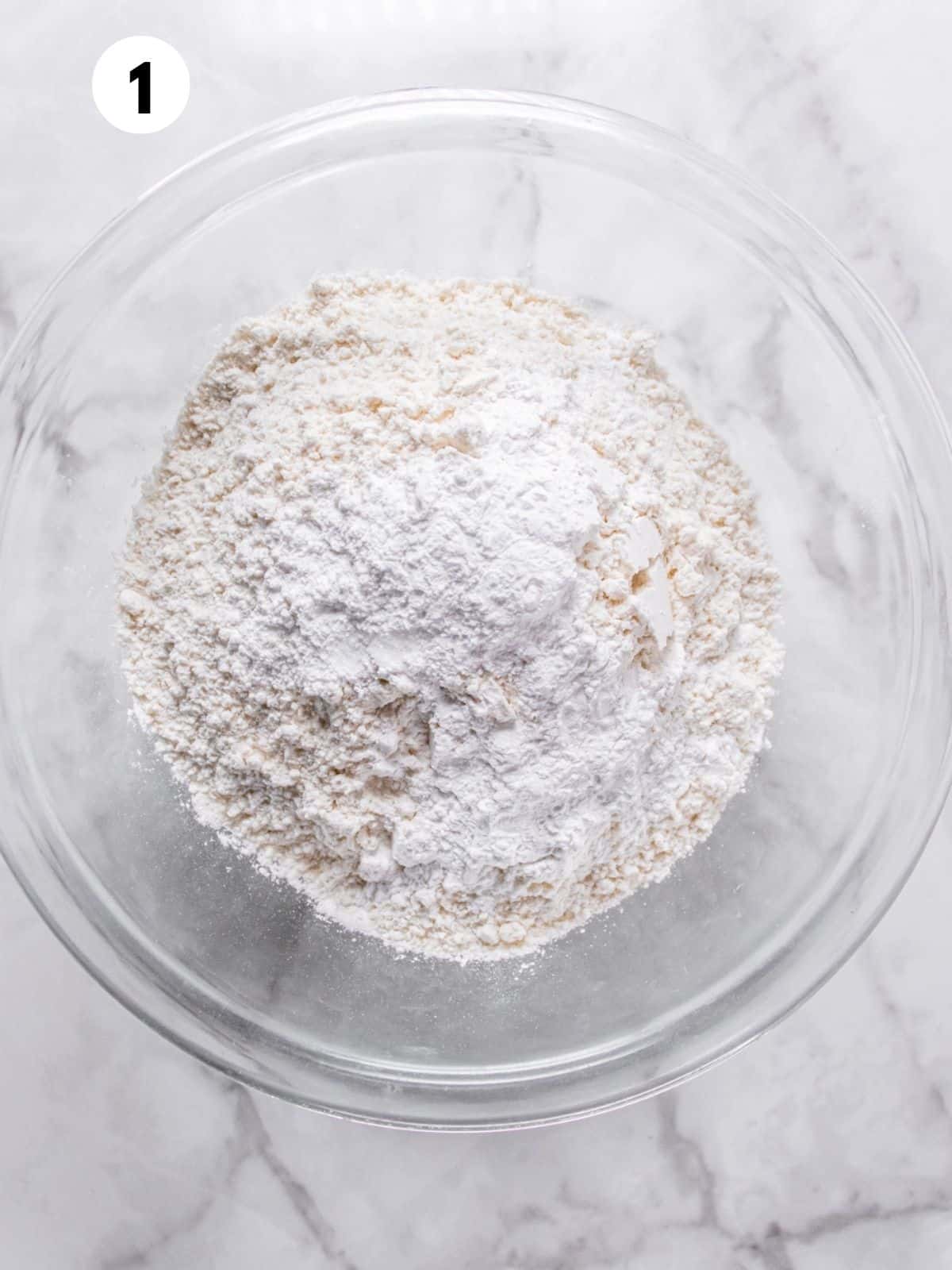 A white glass bowl containing the dry ingredients for low sugar cookie bars.