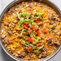 A skillet of cheeseburger pasta on the table ready to dish up.