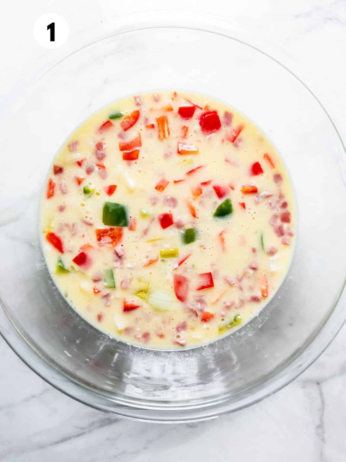 Egg mixture and veggies in a mixing bowl.