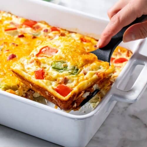 A spatula lifting up a slice of Denver omelete casserole.