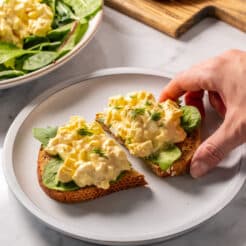 egg salad on a piece of bread on a white plate