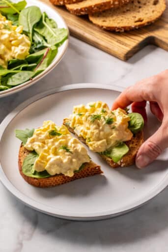 egg salad on a piece of bread on a white plate