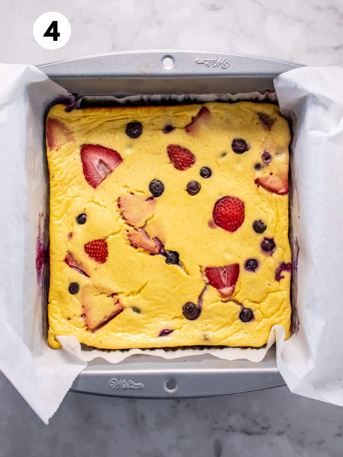 Baked yogurt dessert with berries in a baking dish.