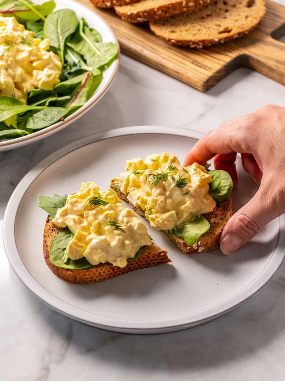 egg salad on a piece of bread on a white plate