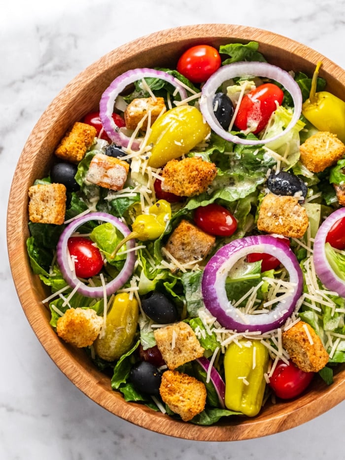 garden salad with cheese and croutons in a wooden bowl