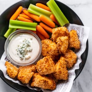 chicken nuggets in a bowl with blue cheese dressing, celery and carrots