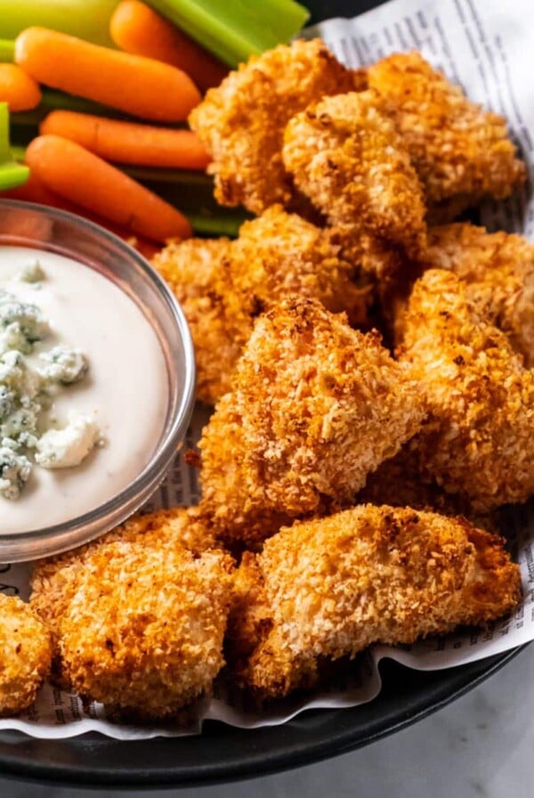 Air fryer buffalo chicken nuggets in a bowl with blue cheese dressing, celery and carrots