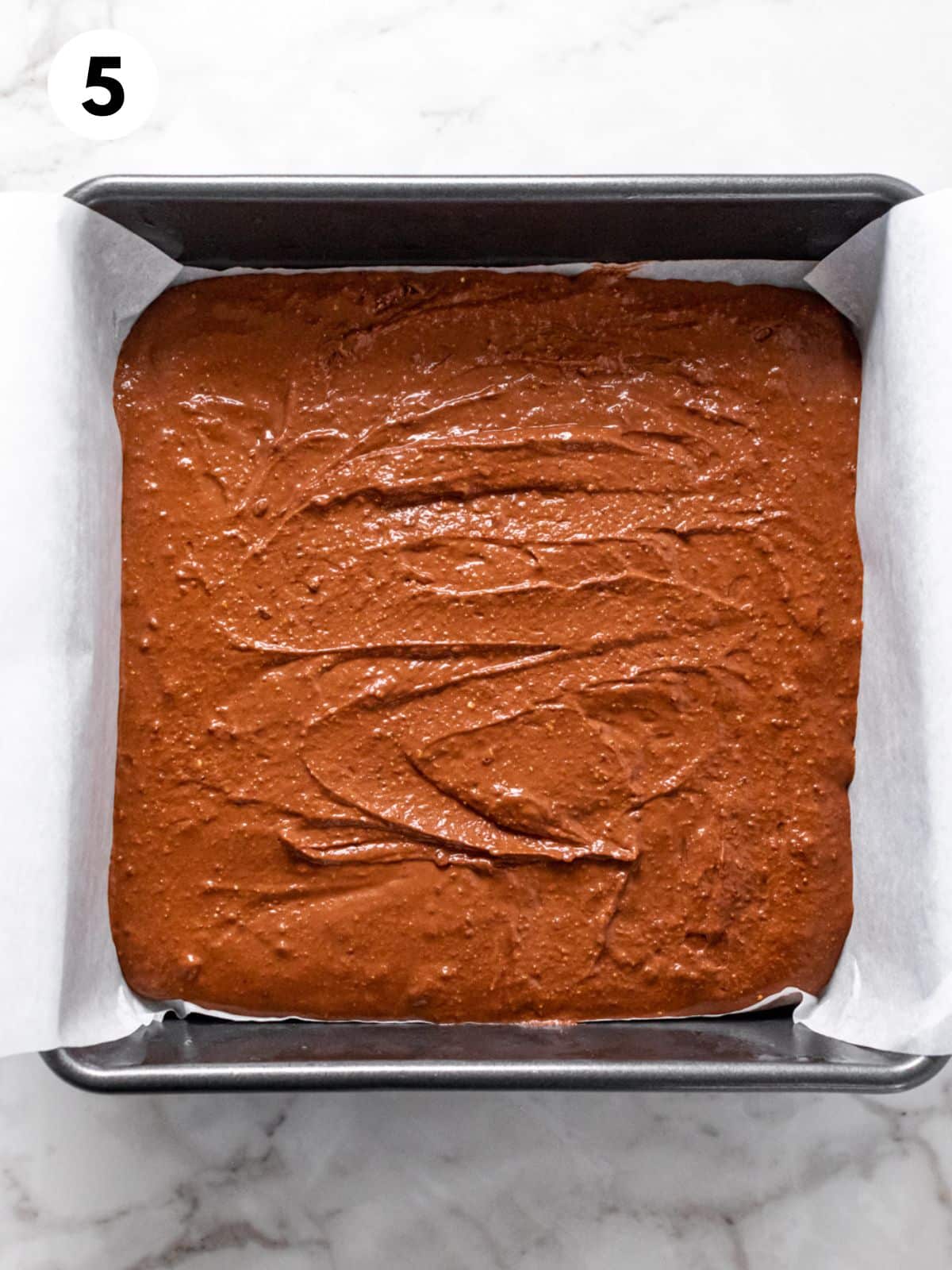 Brownie batter poured into a baking dish.