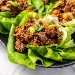 Ground beef lettuce wrap on a platter with more in the background.