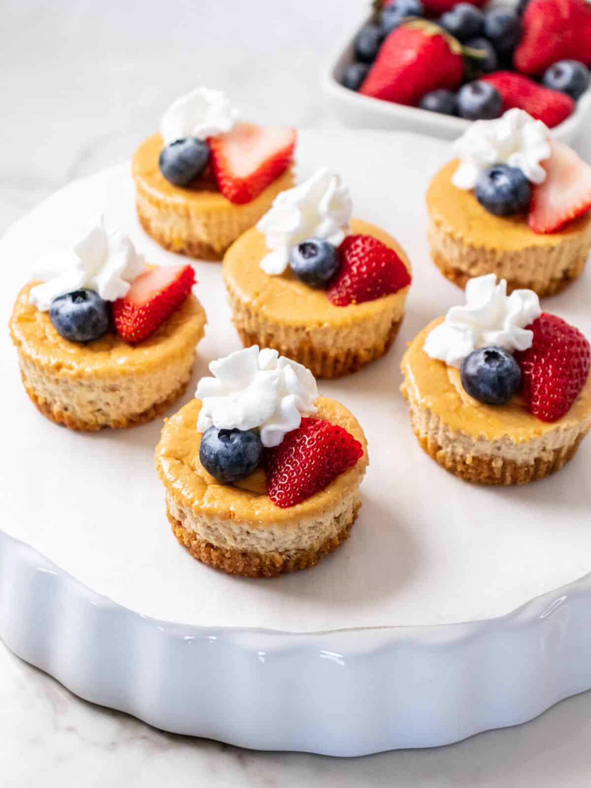 Healthy Mini Protein Cheesecakes are a low fat treat made with Greek Yogurt, lower in sugar and delicious! These healthier cheesecakes will soon become your favorite dessert recipe!