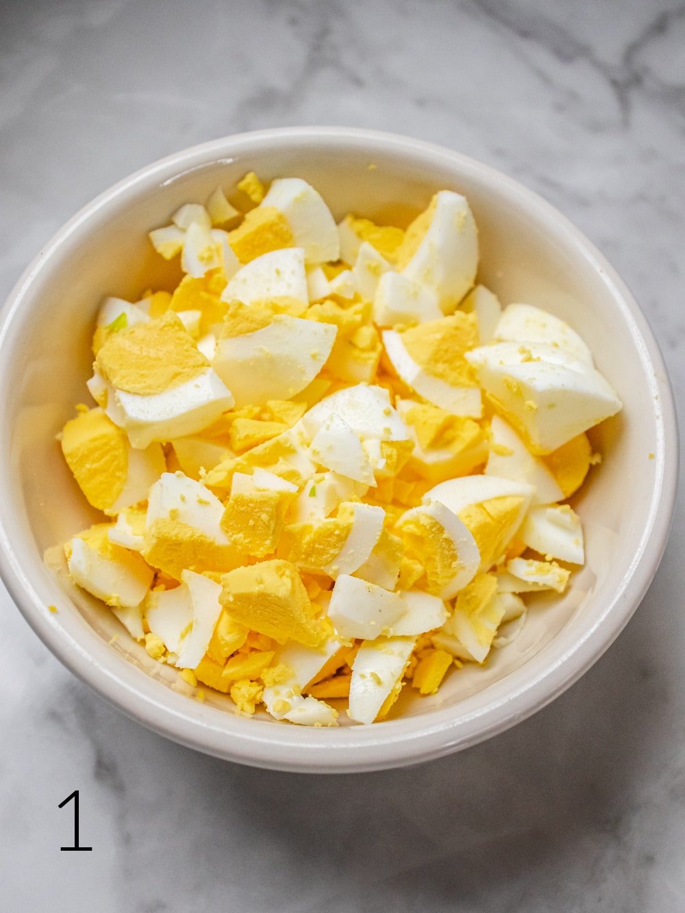 hard boiled eggs chopped in a white bowl