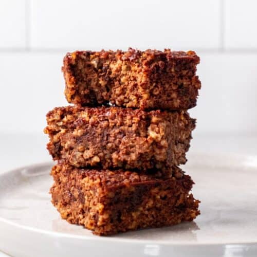 Quinoa brownies cut into squares and stacked on top of each other.