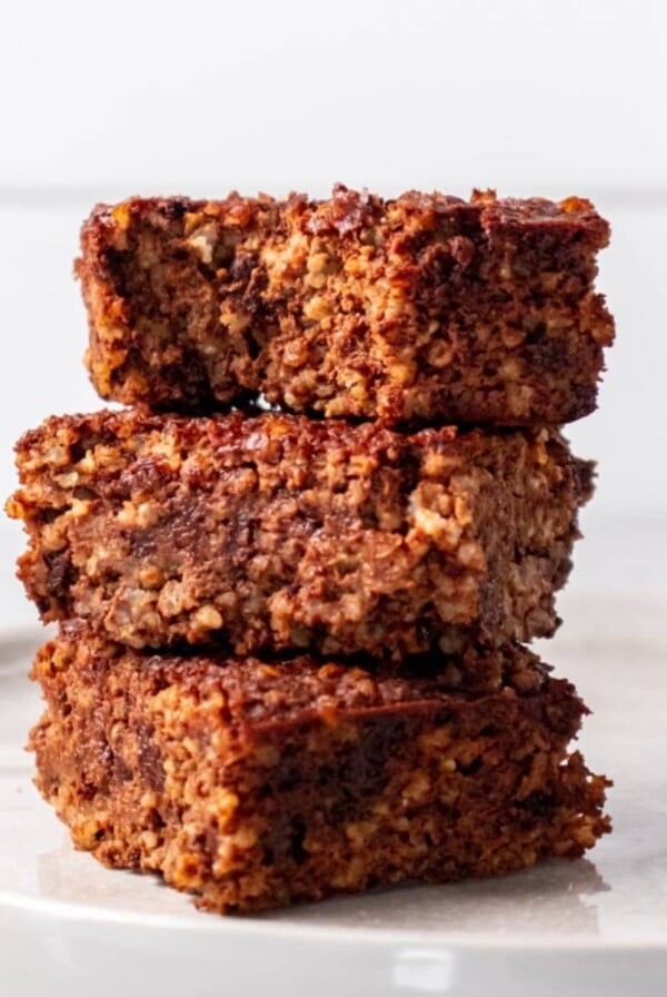 Quinoa brownies cut into squares and stacked on top of each other.
