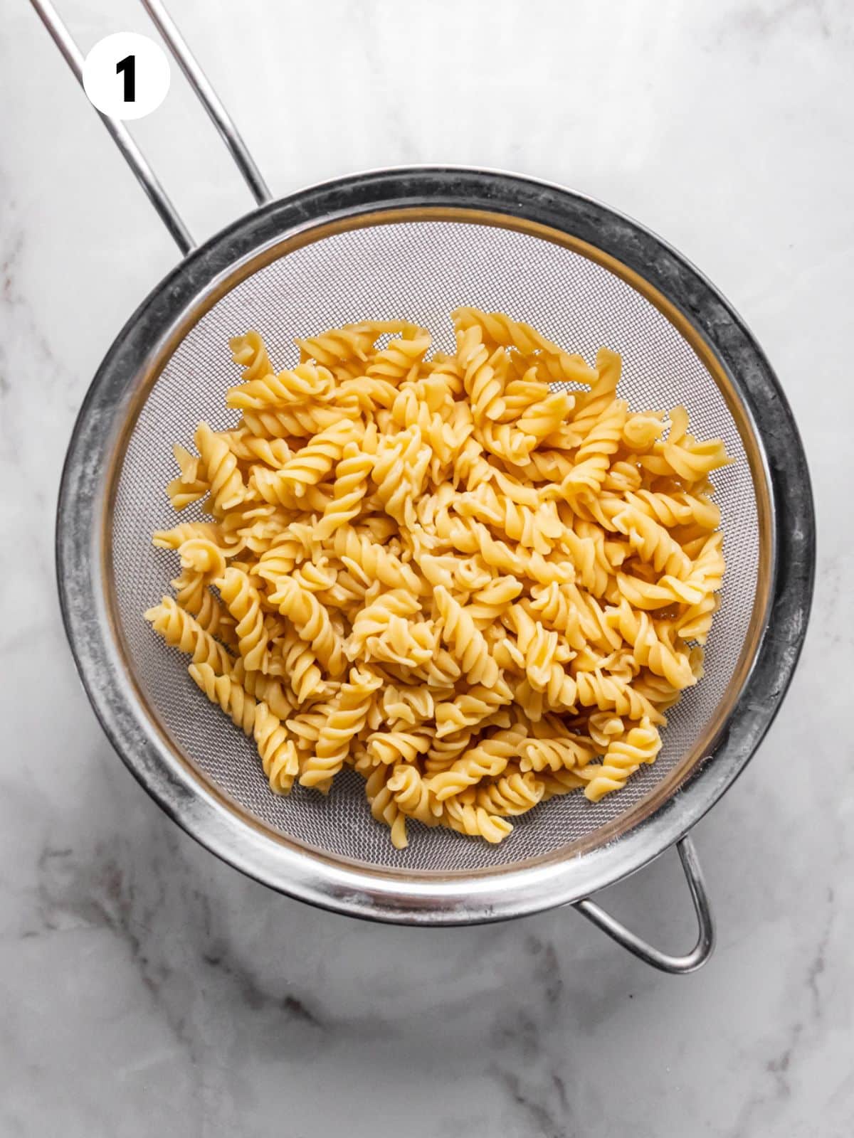 Cooked pasta drained in a colander.