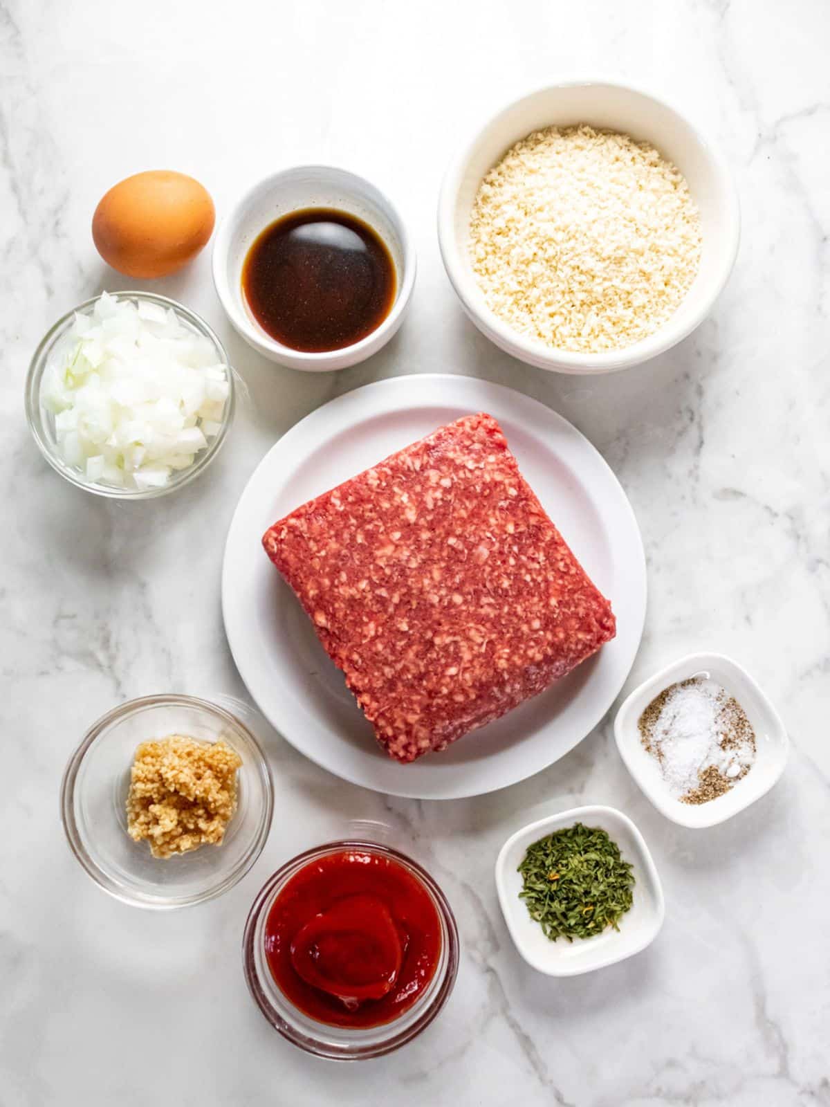 Ingredients needed to make a 1 lb meatloaf on the table before mixing.