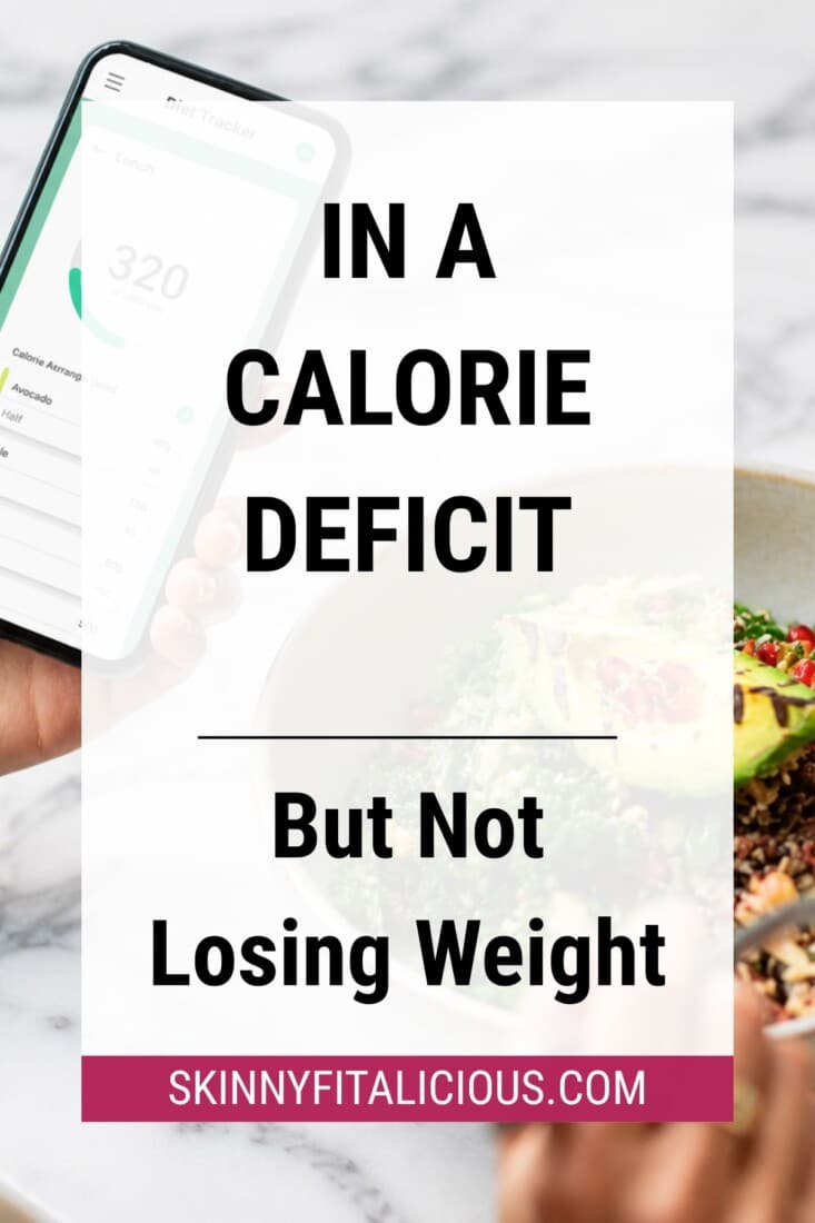 Person tracking calories on a smartphone while eating a healthy meal, illustrating challenges of losing weight in a calorie deficit.