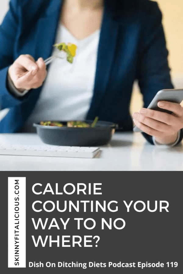 woman in a white t-shirt and blue jacket eating looking at her phone.