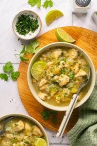 white bowl with chicken soup on a cutting board.