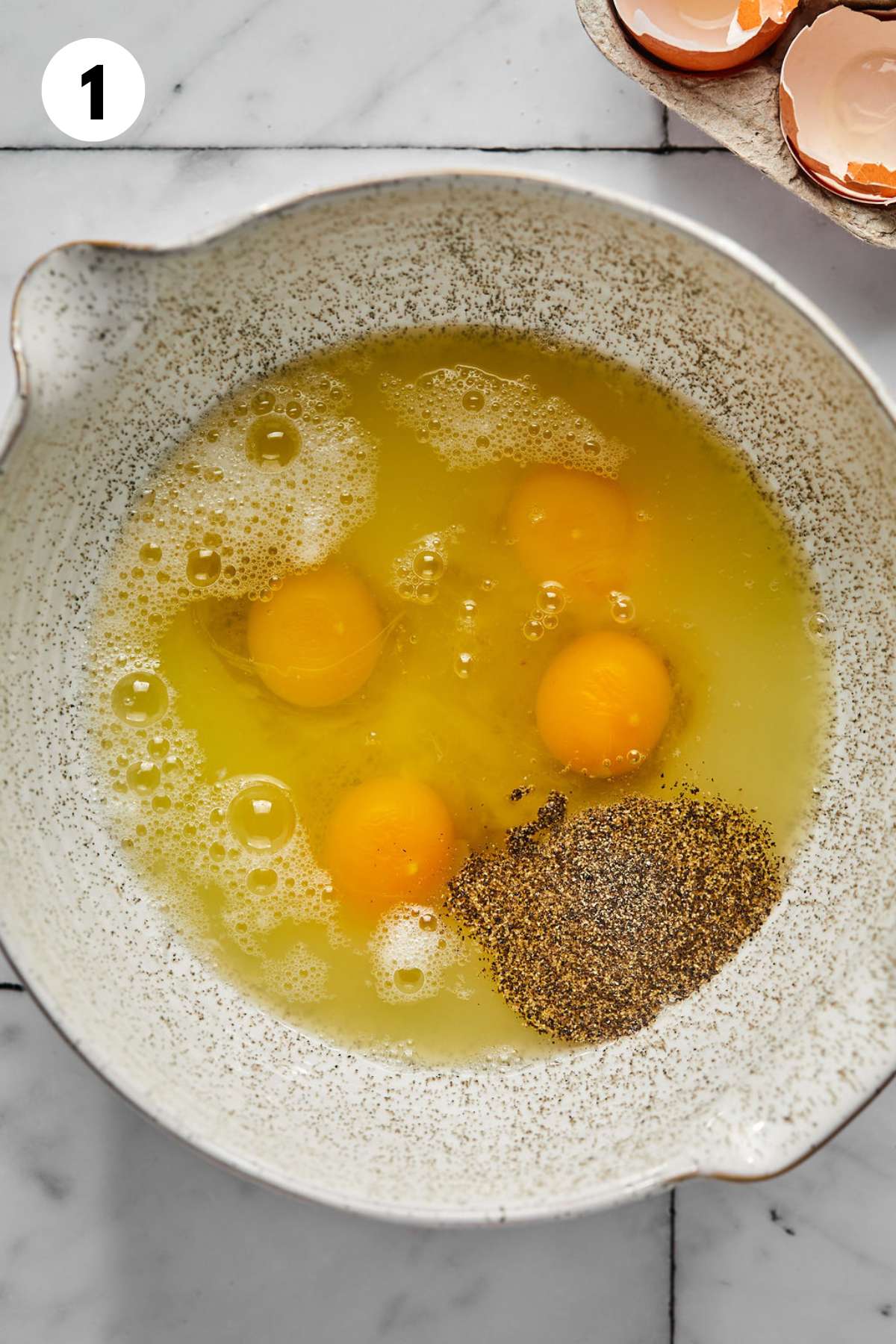 Eggs, egg whites, and seasonings in a bowl.