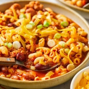 A bowl of high protein chili mac on the table with a spoon in the bowl.