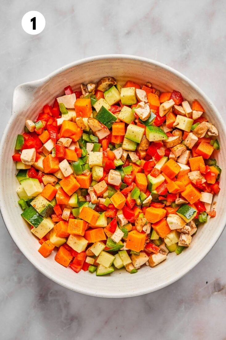 Chopped vegetables in a bowl to toss with olive oil.