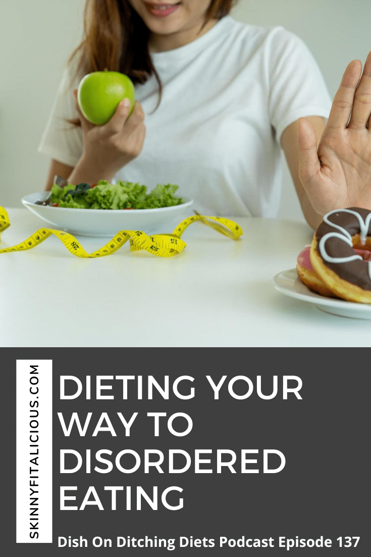 woman in a white t-shirt with a green apple pushing a donut away.