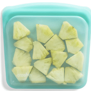 green reusable storage bag with pineapple slices inside.