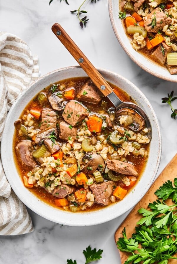 A pot full of beef and barley soup.