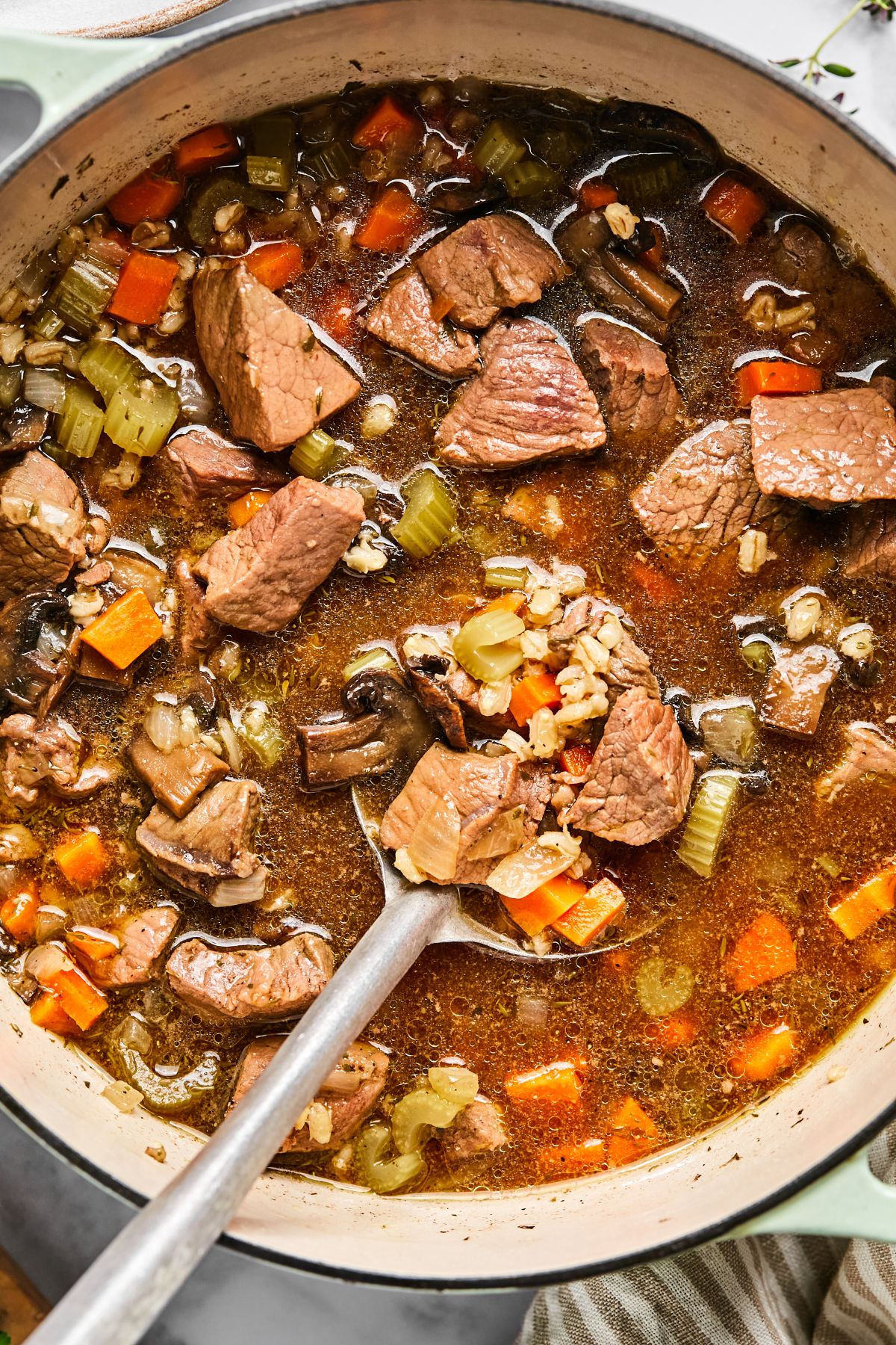 A pot full of beef and barley soup.