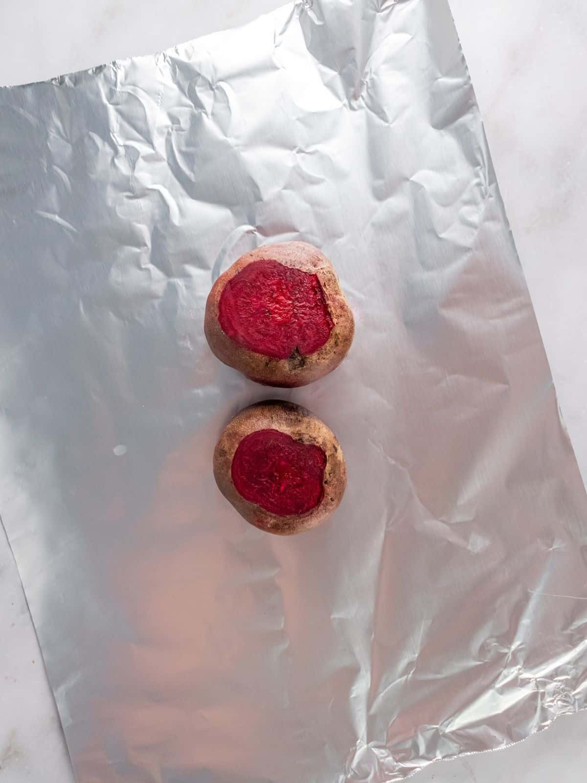 Two beets on a sheet of foil.