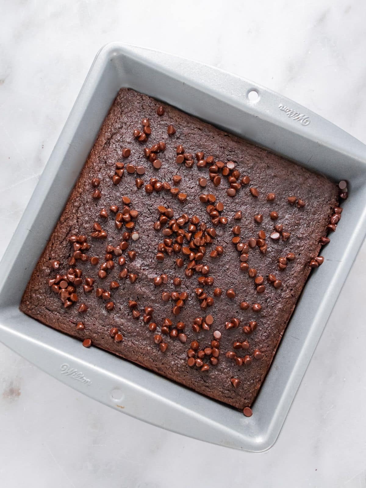 Brownies cooked and topped with chocolate chips.