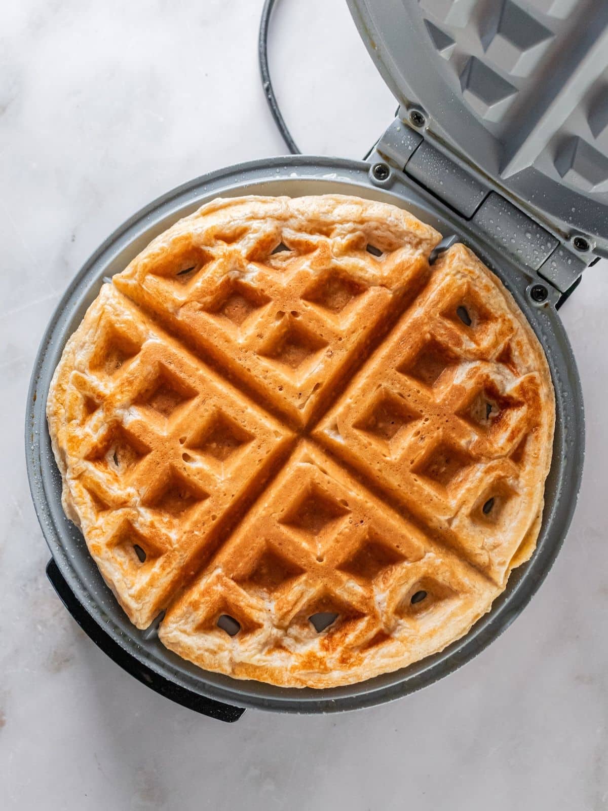 Waffle batter in a waffle iron to cook.