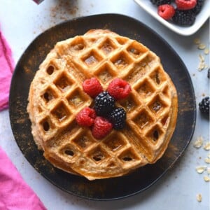 Cottage cheese waffles with raspberries and blackberries on top on a plate.