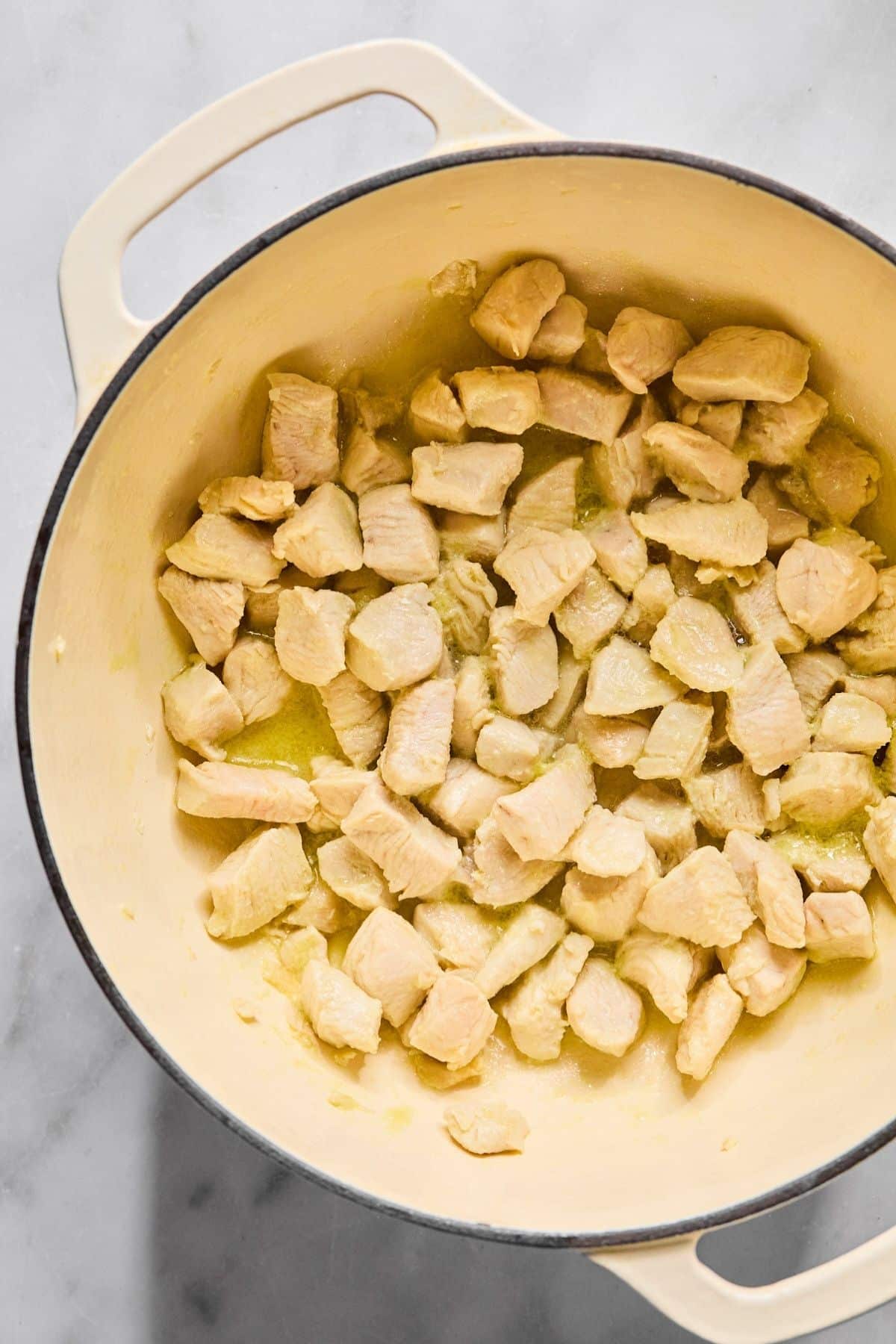 Cooking the chicken to make creamy gnocchi soup in a Dutch oven.