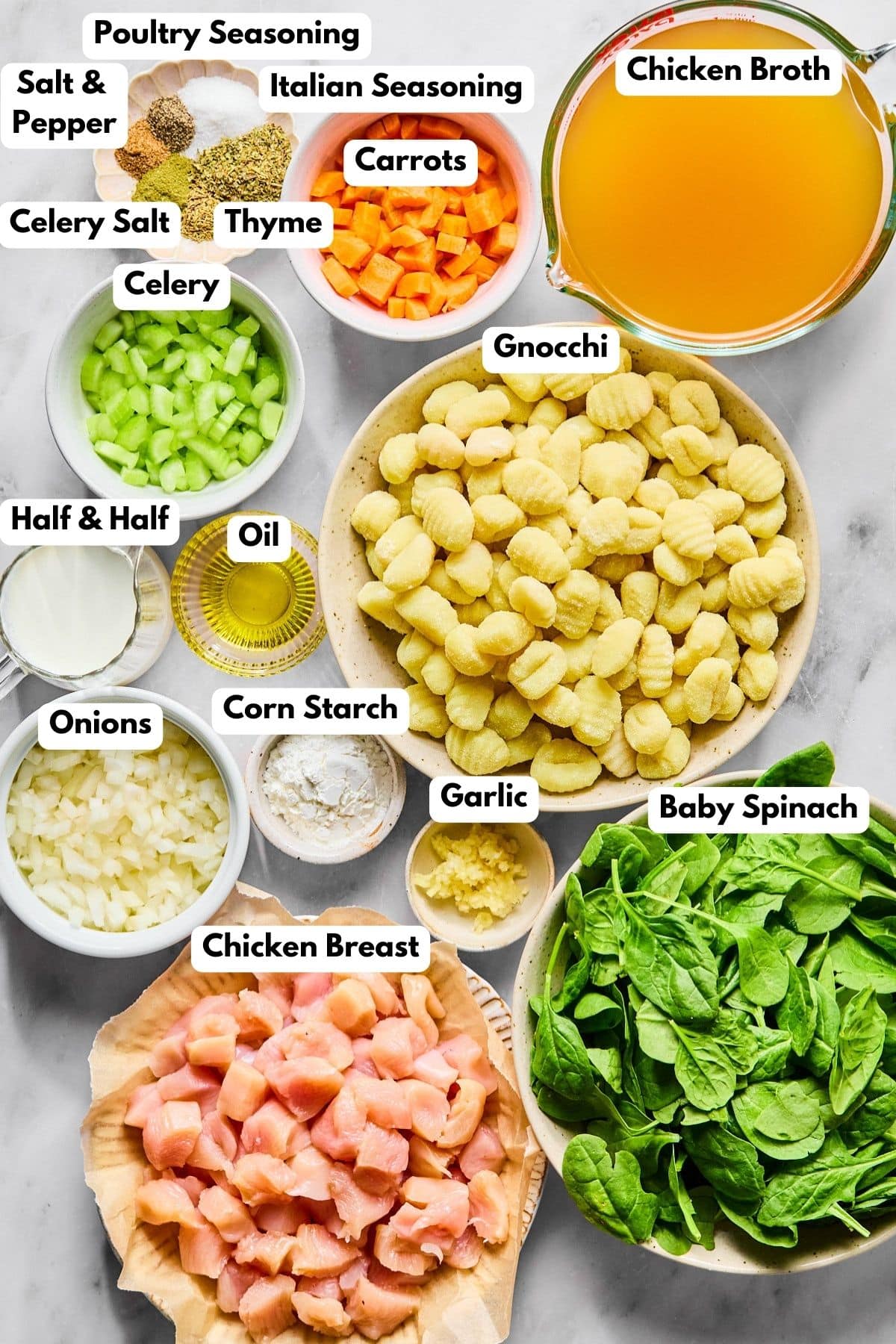 Ingredients to make chicken and gnocchi soup in bowls on a table.