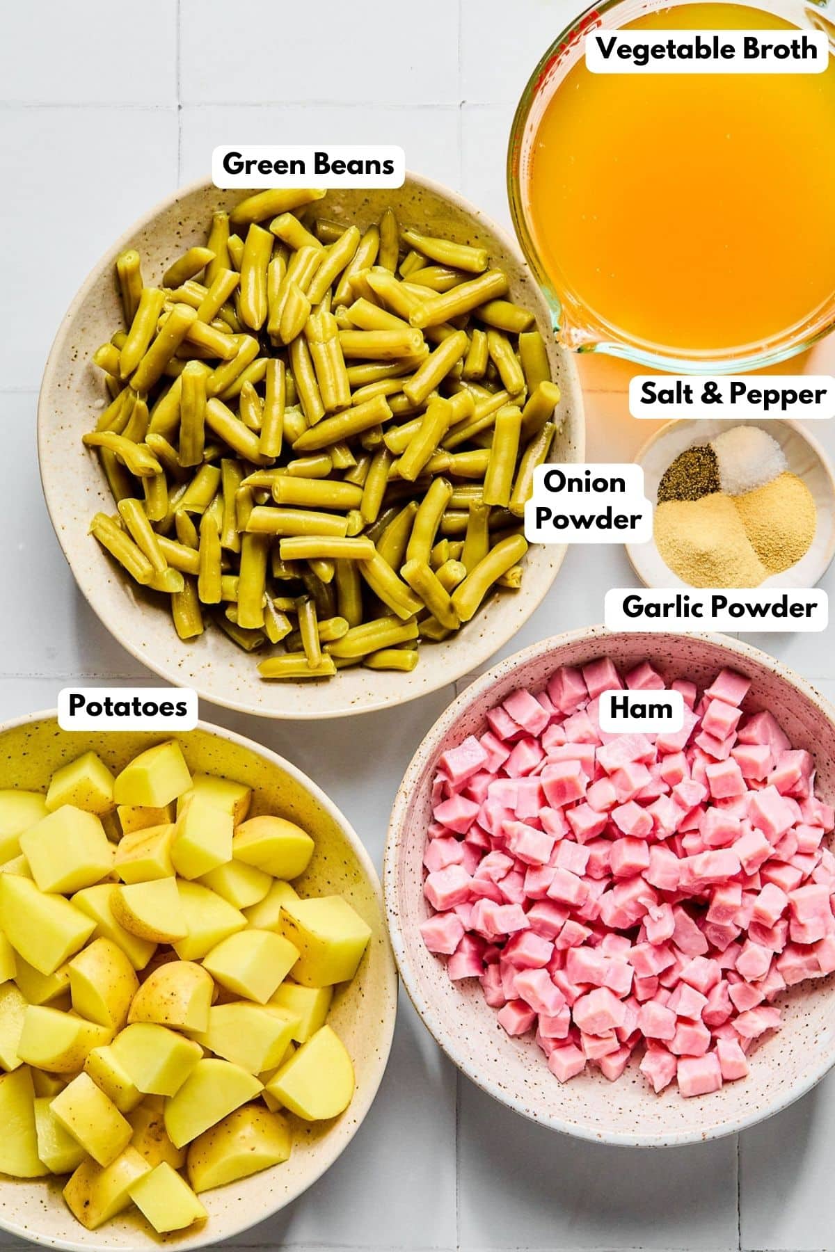 Ingredients to make this ham and potato stew in bowls on a table.