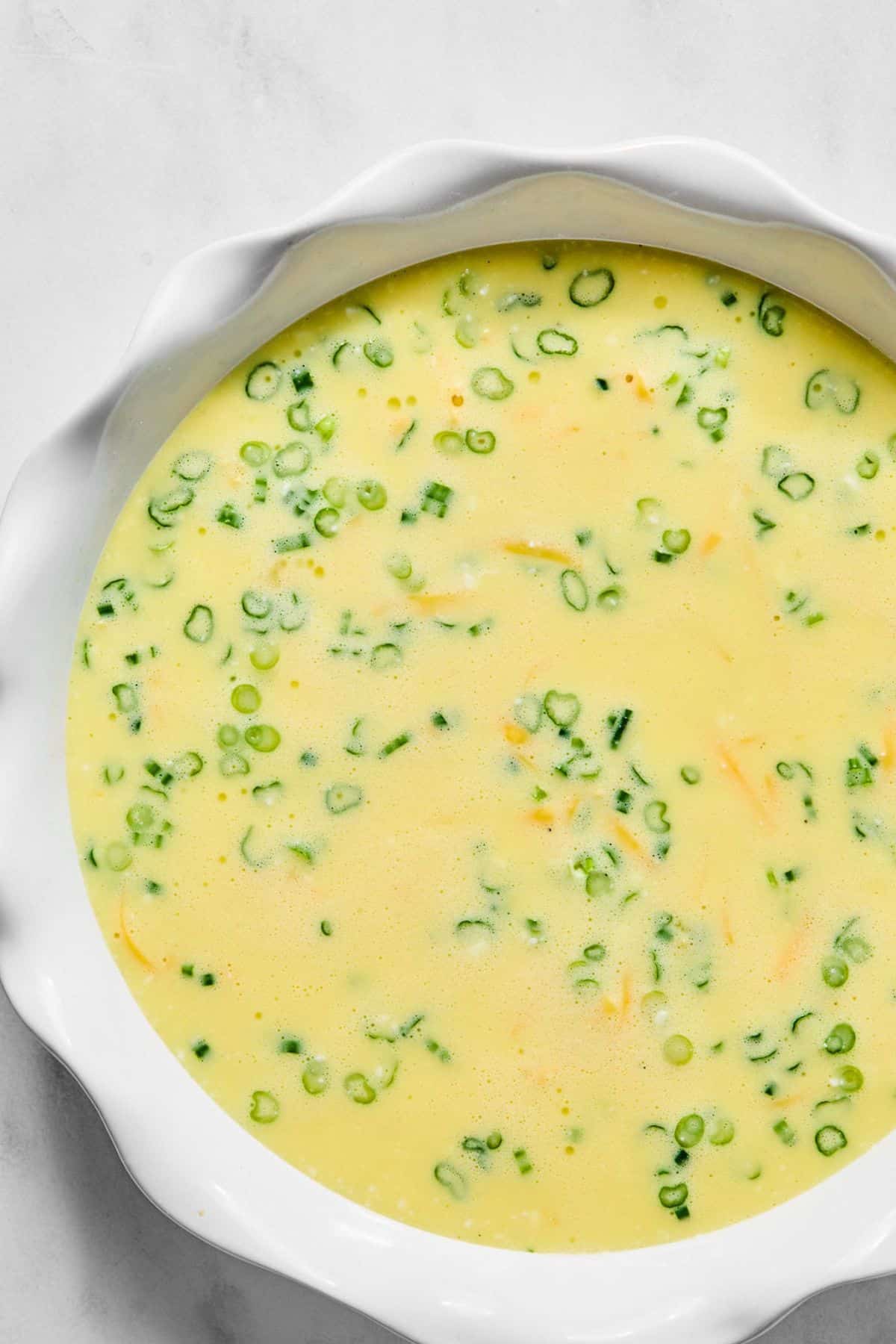Quiche mixture in a round baking dish.