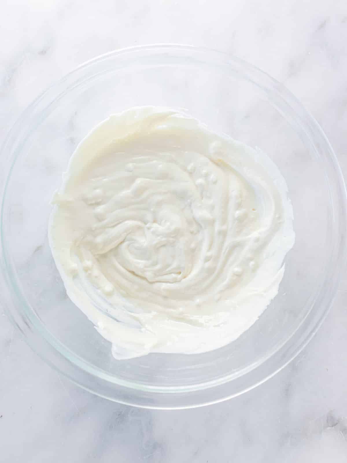 Cream cheese in a mixing bowl after beating until smooth and creamy.