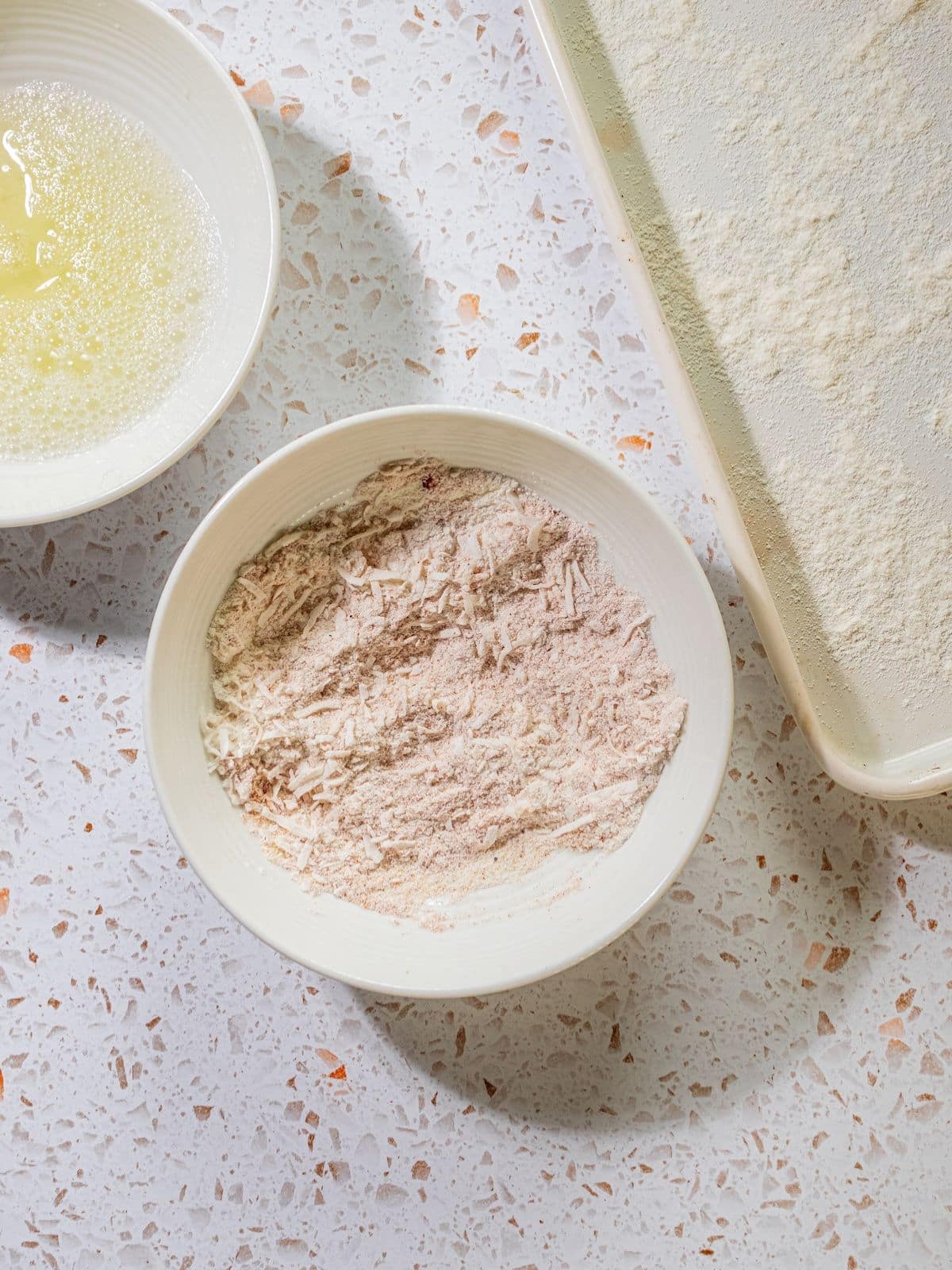 The flour, egg and sheet pan set up to bread.